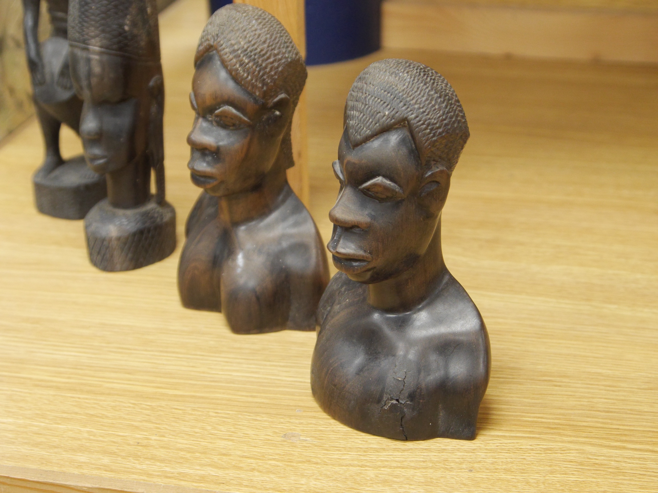 Four African wood carvings to include a figure and a pair and another bust, tallest 27cm. Condition - fair to good